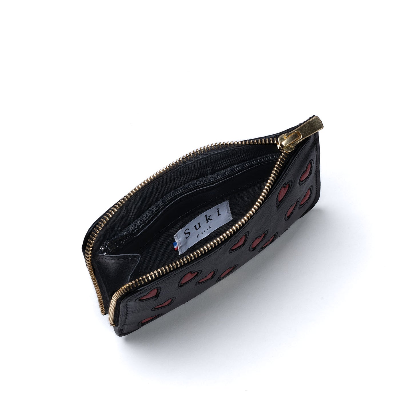 Atelier de maroquinerie à Paris. Porte feuille créateur en cuir made in France. Maroquinerie fantaisie fabriquée en petite série à Paris 17. Petite maroquinerie personnalisable, parfait pour idée cadeau. Portefeuille avec coeurs en cuir italien, tannage végétal. Savoir-faire artisanal pour une mode éthique locale et engagée.