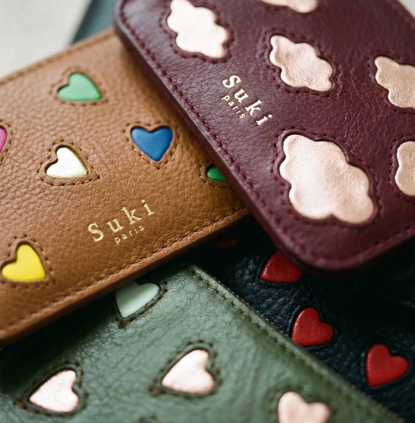 Stacked leather purses — inlaid heart and flower motifs, four colourways, Suki Paris atelier